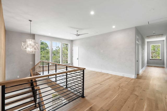 unfurnished room featuring light wood-style floors, baseboards, a chandelier, recessed lighting, and attic access