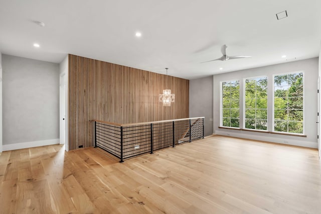 spare room featuring wood finished floors, a chandelier, ceiling fan, recessed lighting, and baseboards