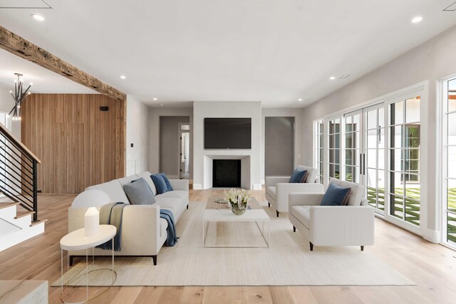 living area featuring wood finished floors, stairs, a fireplace, and recessed lighting