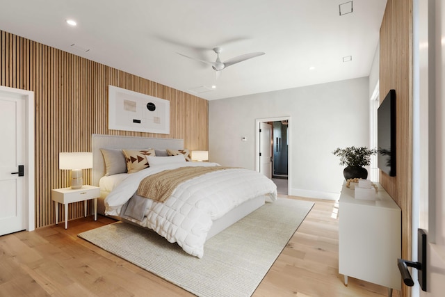 bedroom featuring light wood-style flooring, baseboards, an accent wall, ceiling fan, and recessed lighting