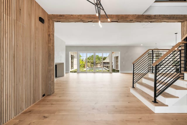 foyer entrance with wood finished floors, stairway, and beamed ceiling