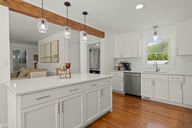 kitchen featuring stainless steel dishwasher, a sink, hanging light fixtures, and tasteful backsplash