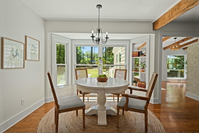dining space featuring an inviting chandelier, wood finished floors, beamed ceiling, and baseboards