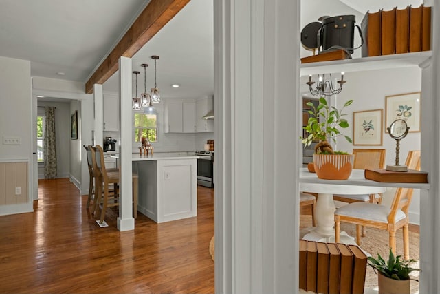 interior space featuring stainless steel electric range, wood finished floors, and an inviting chandelier