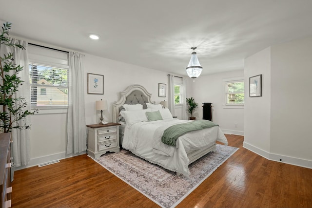 bedroom featuring recessed lighting, an inviting chandelier, wood finished floors, visible vents, and baseboards