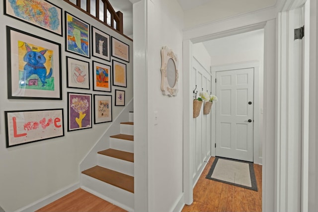 interior space featuring baseboards, wood finished floors, and stairway