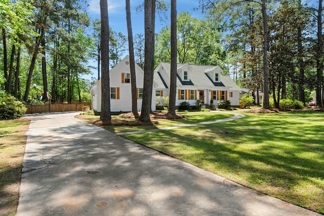 view of front of property featuring driveway, a front yard, and fence