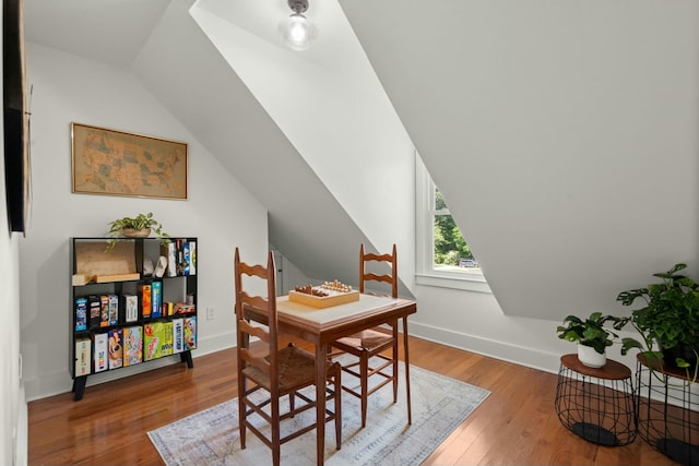 dining room with lofted ceiling, baseboards, and wood finished floors