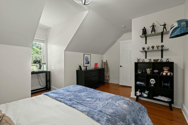 bedroom featuring baseboards, vaulted ceiling, and wood finished floors
