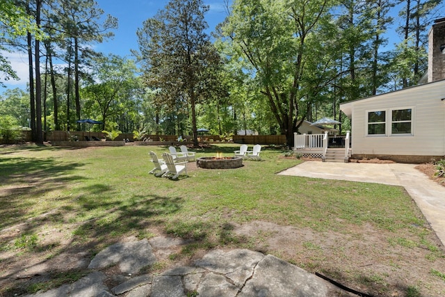 view of yard with a wooden deck, a patio area, an outdoor fire pit, and fence