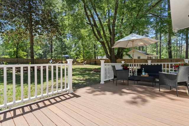 deck featuring a fenced backyard, a lawn, and an outdoor hangout area
