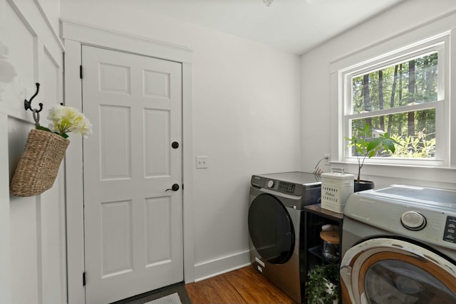 laundry area featuring separate washer and dryer, baseboards, wood finished floors, and laundry area