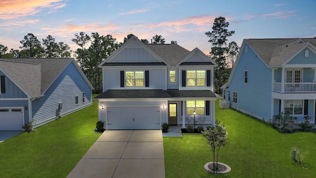 craftsman inspired home with a balcony, a garage, and a yard