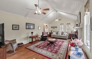 living area with wood finished floors, a ceiling fan, and lofted ceiling