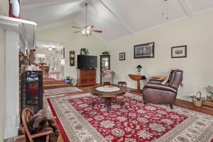 living area with a ceiling fan and vaulted ceiling