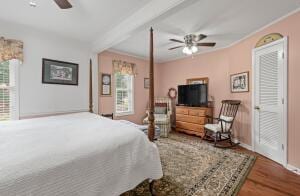 bedroom featuring baseboards, a ceiling fan, wood finished floors, and crown molding