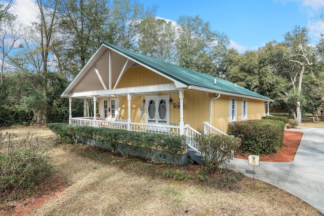 view of front of home featuring french doors, covered porch, and metal roof