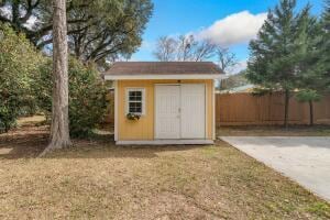 view of shed with fence and driveway