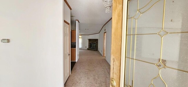 hallway featuring light colored carpet and a textured ceiling