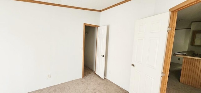 unfurnished bedroom featuring light carpet and ornamental molding