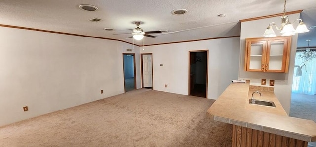 kitchen with ceiling fan with notable chandelier, crown molding, sink, carpet flooring, and decorative light fixtures