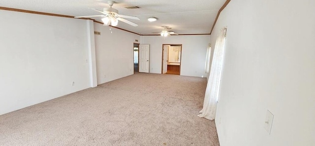 spare room featuring light carpet, crown molding, and ceiling fan