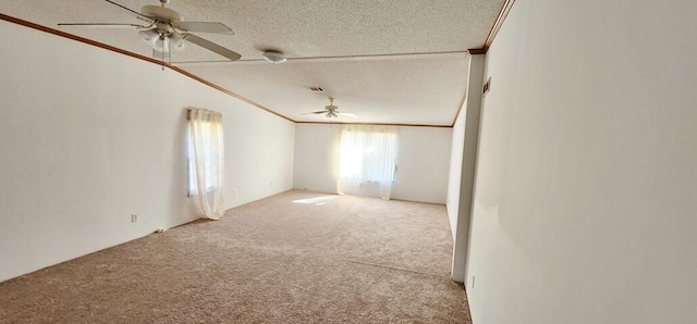 carpeted spare room with a textured ceiling, ceiling fan, and ornamental molding