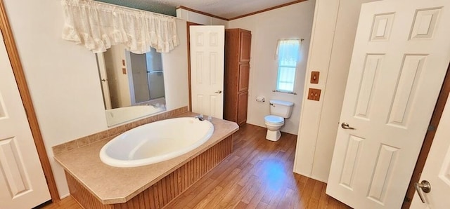 bathroom with a washtub, a textured ceiling, crown molding, wood-type flooring, and toilet