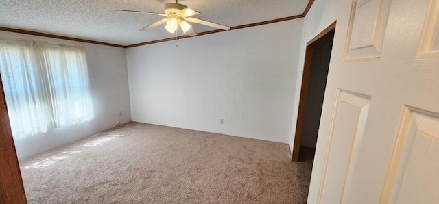 carpeted empty room with ceiling fan, a textured ceiling, and ornamental molding