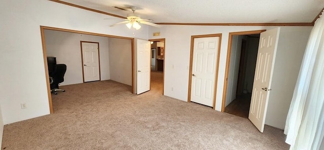 unfurnished bedroom featuring light carpet, a textured ceiling, vaulted ceiling, and ceiling fan