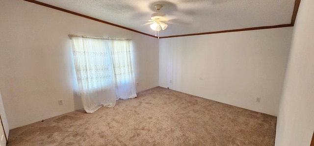 carpeted empty room with ceiling fan, lofted ceiling, a textured ceiling, and ornamental molding