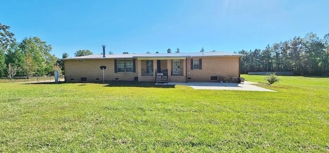 back of house featuring a lawn and a patio