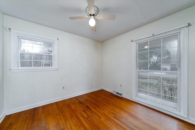 empty room with hardwood / wood-style floors, a textured ceiling, and ceiling fan