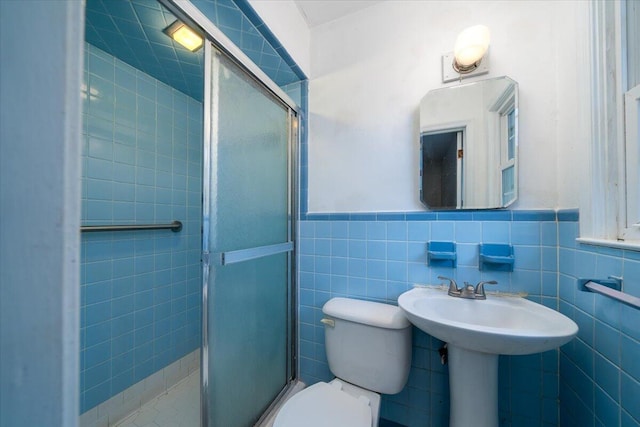 bathroom featuring tile walls, toilet, and walk in shower