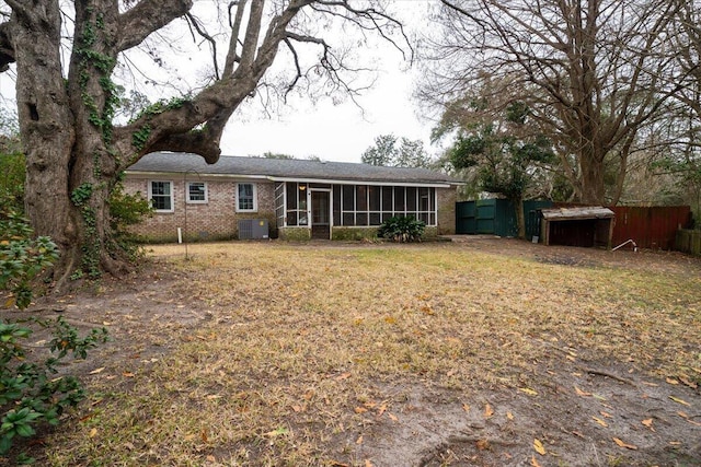 back of property with a sunroom, a lawn, and central air condition unit