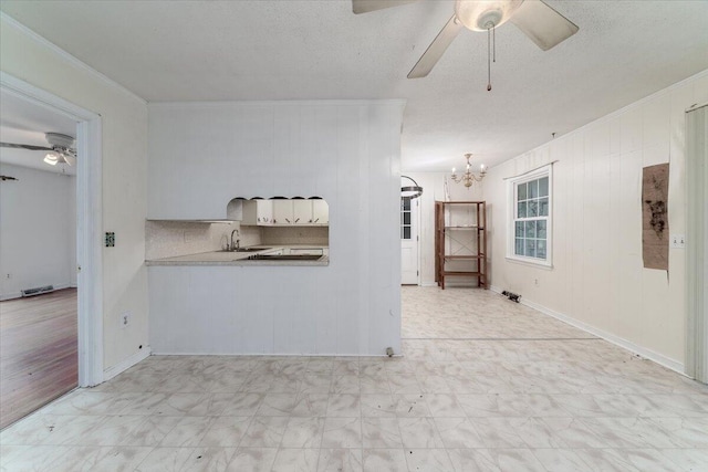 interior space with crown molding, sink, ceiling fan with notable chandelier, and a textured ceiling