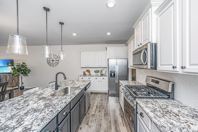 kitchen with sink, white cabinetry, stainless steel appliances, and hanging light fixtures