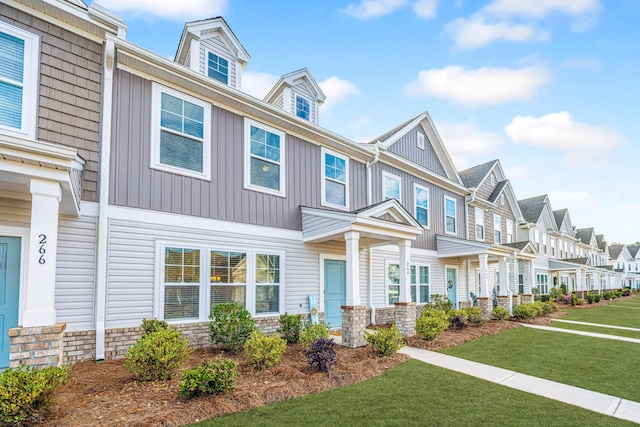 townhome / multi-family property featuring a front lawn