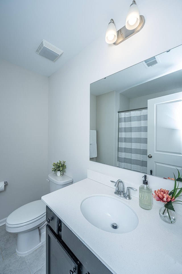 bathroom featuring tile patterned flooring, vanity, and toilet