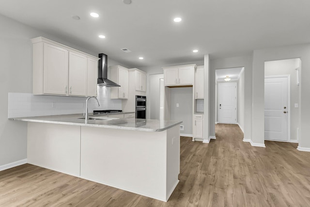 327 Hillman Trl Dr, Moncks Corner, SC 29461 - kitchen with wall chimney exhaust hood, a peninsula, light wood-style floors, double oven, and recessed lighting