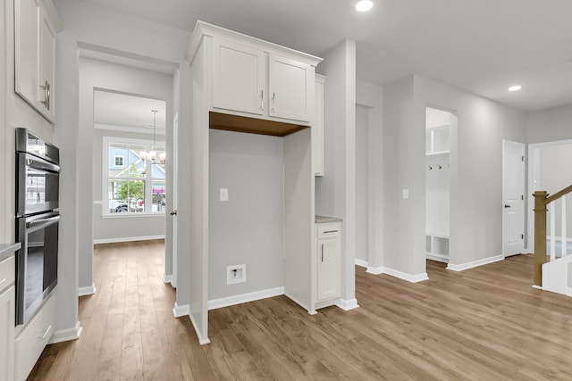 327 Hillman Trl Dr, Moncks Corner, SC 29461 - kitchen with stainless steel double oven, light wood-style floors, white cabinets, a chandelier, and baseboards