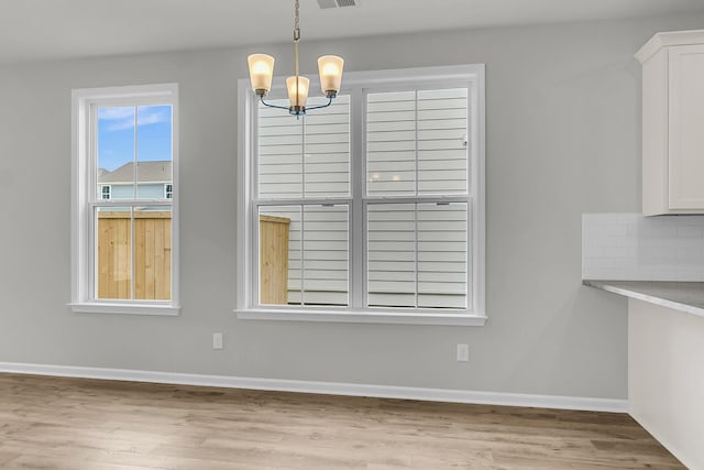 327 Hillman Trl Dr, Moncks Corner, SC 29461 - unfurnished dining area with light wood-type flooring, a chandelier, and baseboards