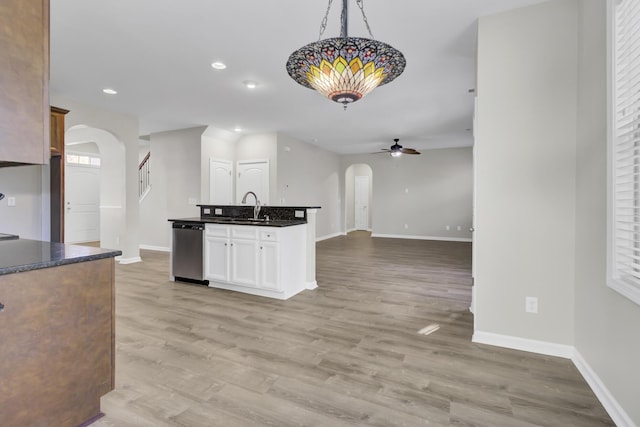 kitchen featuring stainless steel dishwasher, ceiling fan, pendant lighting, light hardwood / wood-style floors, and white cabinetry