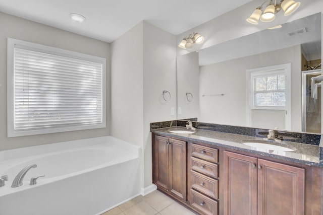 bathroom with tile patterned flooring, vanity, and a tub to relax in