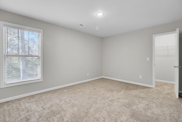 unfurnished room featuring light carpet