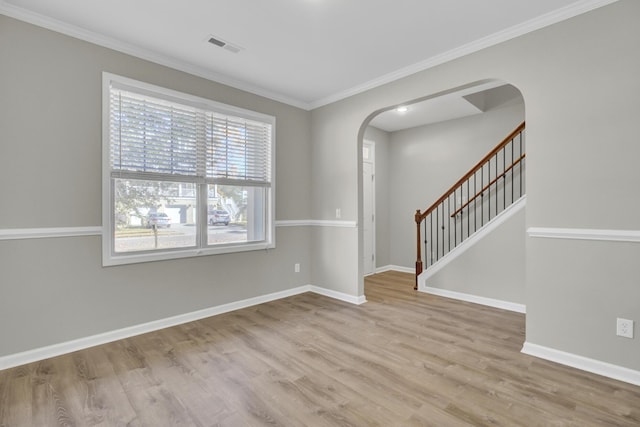 spare room with ornamental molding and light hardwood / wood-style flooring