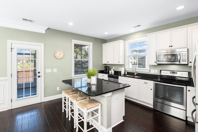 kitchen featuring visible vents, appliances with stainless steel finishes, a center island, and a sink