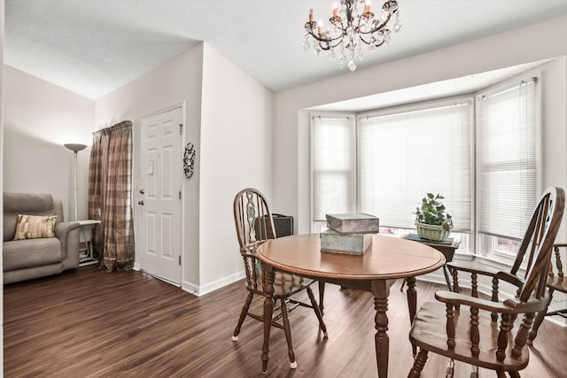 dining area featuring baseboards, dark wood-style flooring, a notable chandelier, and a healthy amount of sunlight