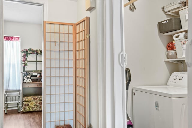 laundry area with laundry area, washer / dryer, and wood finished floors