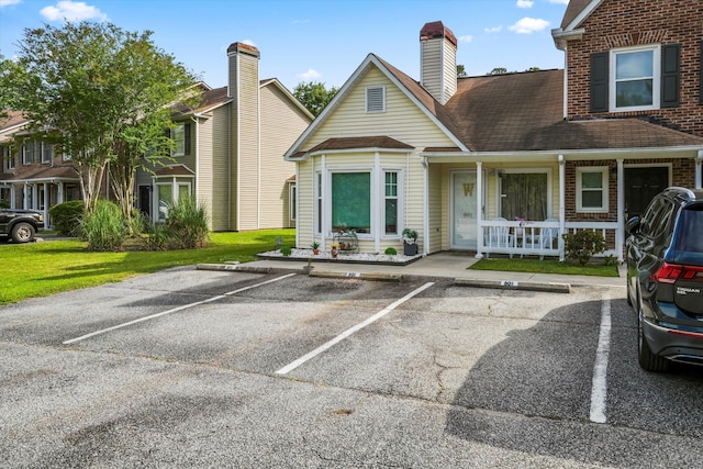 view of front of property with a porch and uncovered parking